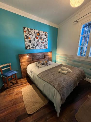 a bedroom with a bed and a painting on the wall at BbCasita Yellow in Valparaíso