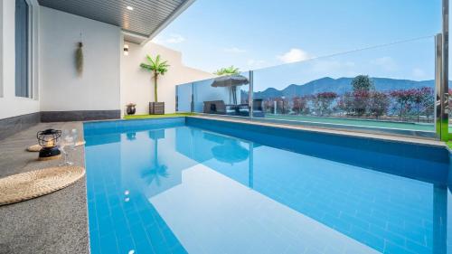a swimming pool with a view of a house at Namhae Eagless Poolvilla Pension in Namhae