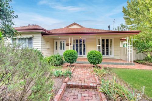 a house with a brick walkway in front of it at Ayr House - Echuca Holiday Homes in Echuca