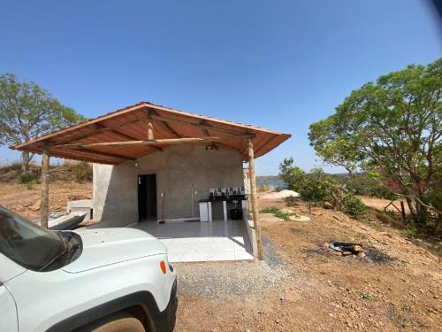 a white truck parked in front of a building at Los Arboles - Quarto com Banheiro in Alexânia