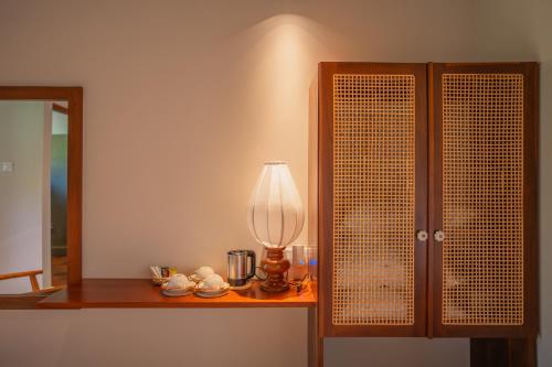 a lamp sitting on a table next to a cabinet at Tranquil Trails Sigiriya in Dambulla