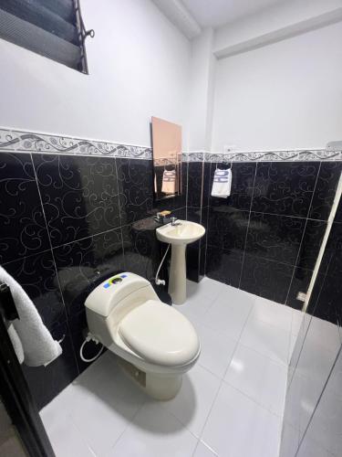 een badkamer met toilet en wastafel bij Hotel Ensueño in Pereira