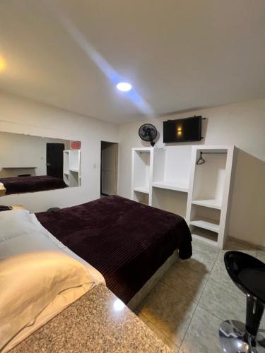 een slaapkamer met een bed en een tv aan de muur bij Hotel Ensueño in Pereira