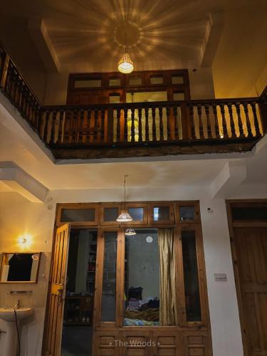 a living room with a wooden staircase and a balcony at The Woods - Tirthan Valley in Gushaini