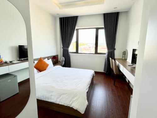 a hotel room with a bed and a window at SAFFRON Dalat in Da Lat