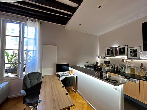 une cuisine avec une table en bois et un bar dans l'établissement Fantastique et Incroyable appartement Le Marais Paris, à Paris