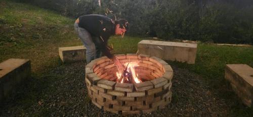 a man standing next to a brick fire pit at San Felipe Lodge. Birding and Wellness in Cali