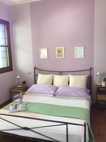 a bedroom with a large bed with purple walls at Sweet Home & Apartments in Fontane Bianche