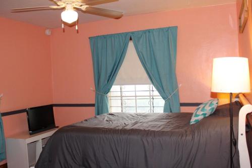 a bedroom with a bed with blue curtains and a window at Charming Modern Retreat Near Downtown Jeffersonville & Bob Hedge Park in Jeffersonville