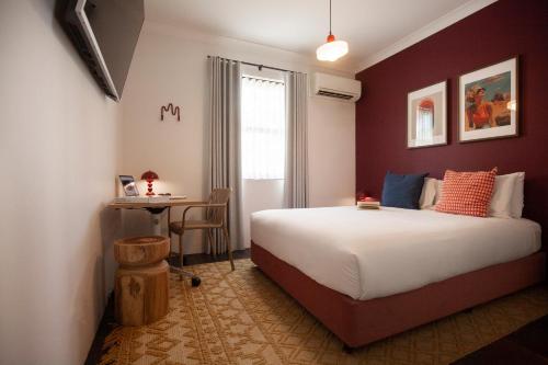 a bedroom with a large bed and a table at Little Drifter Surry Hills in Sydney