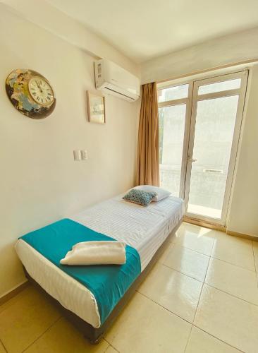 a bedroom with a bed with a clock and a window at Alberca privada, vista al mar, frente playa foro boca in Boca del Río