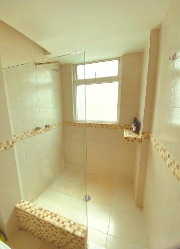 a shower with a glass door in a bathroom at Alberca privada, vista al mar, frente playa foro boca in Boca del Río
