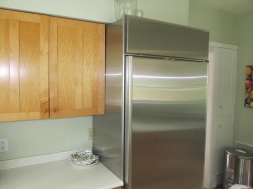 a stainless steel refrigerator in a kitchen with wooden cabinets at The Master Bedroom at the Hillside B&B in Wisconsin Dells