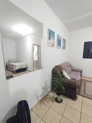 a living room with a couch and a mirror at Ap SOL in Piracicaba