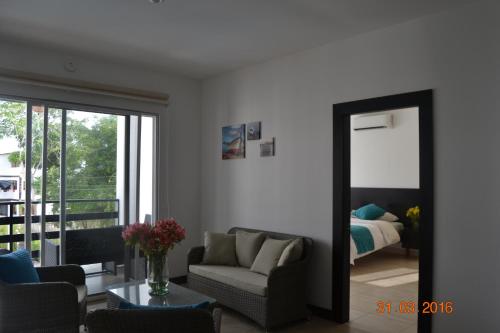 a living room with a mirror and a couch and a bed at Ocean Blue Hotel in Olón