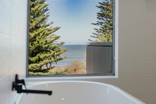 a bathroom mirror with a view of the ocean at The Dual Family Entertainer 9 Esplanade Victor Harbor - Linen Included - Luxury - Seafront in Victor Harbor