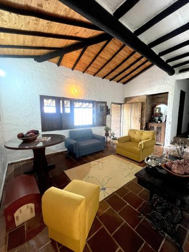 a living room with yellow chairs and a table at Mirador Villa El Oasis in Piedecuesta