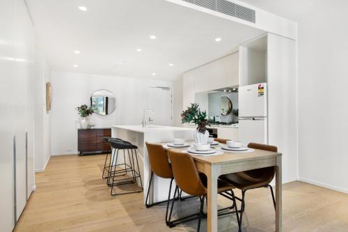 a kitchen and dining room with a table and chairs at Spacious Modern Apartment with Pool & Gym Access in Melbourne
