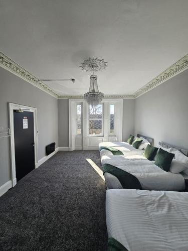 爱丁堡Central Hotel Edinburgh的一间设有四张床和吊灯的客房