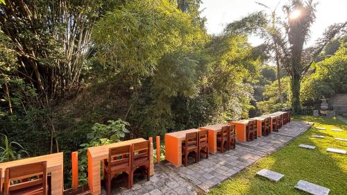 una fila de bancos de madera en un parque en Dur Pekerisan Retreat Villa Ubud, en Ubud