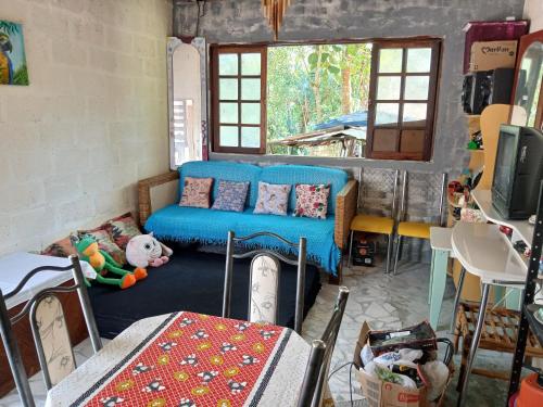 a room with a blue couch and a table at Recanto alegria in São Roque