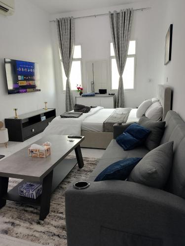 a living room with a bed and a couch at Brand new Stylish Studio Near to Yas & Airport in Abu Dhabi