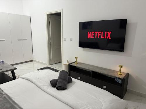 a bedroom with a bed with a television on the wall at Brand new Stylish Studio Near to Yas & Airport in Abu Dhabi