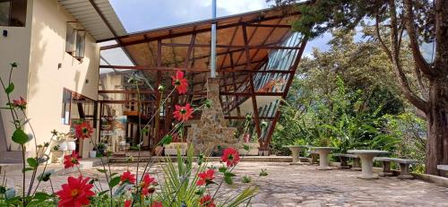 QuillabambaにあるEcoterra Inka Lodgeの正面にベンチと花が咲く建物