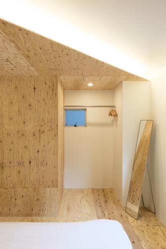 a room with a wooden wall and a window at SHORTsuido in Tokyo
