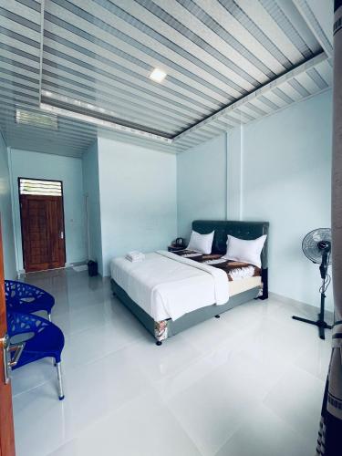 a bedroom with a bed and a chair in it at Vandu's View Guest house & Restaurant in Tuk Tuk