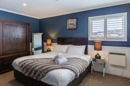 a bedroom with a bed with a teddy bear on it at The Stables Resort Perisher - Open All Year in Perisher Valley
