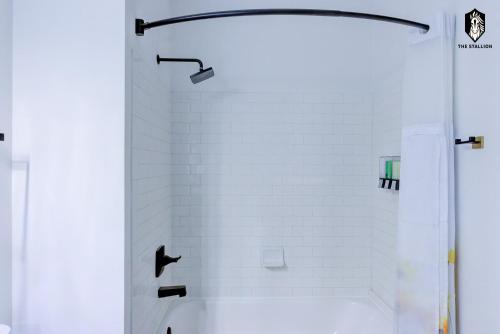 a bathroom with a shower with white tiles at The Stallion #107 - Modern Spacious Loft in Downtown with free parking in Memphis
