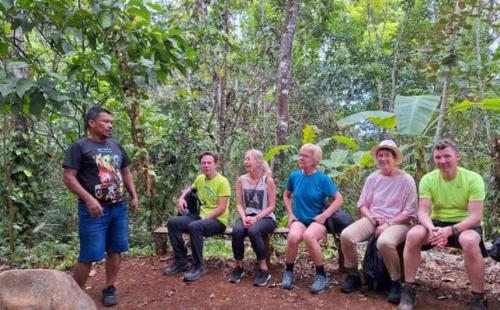 a group of people sitting on a bench in the woods at Centro Etnoturístico El Descanso in Térraba