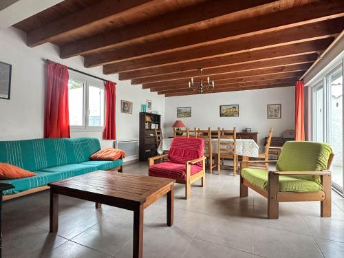 - un salon avec des chaises vertes et rouges et une table dans l'établissement Villa 4 chambres près de la plage avec parking à La Palmyre - FR-1-705-95, aux Mathes