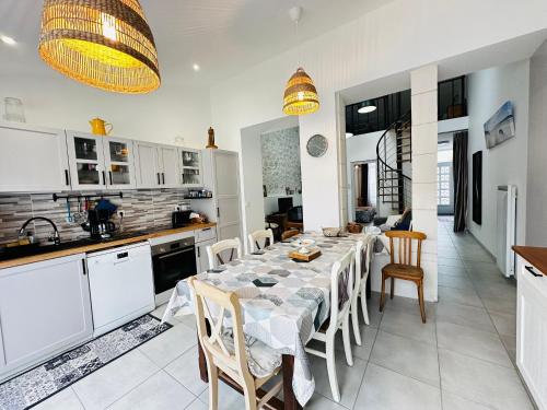 une cuisine et une salle à manger avec une table et des chaises dans l'établissement Charmante maison rénovée près du centre - FR-1-709-91, à Fouras