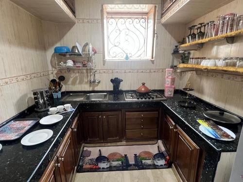 a kitchen with a sink and a counter with plates on the floor at Dar Lala Fatima Zahrae in Rabat
