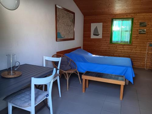 une chambre avec un lit, une table et des chaises dans l'établissement Petite Maison à 500m de la Plage, 300m du Centre – Idéale pour Séjour à Pied! - FR-1-476-5, à La Faute-sur-Mer