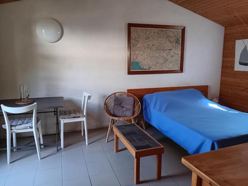 une chambre avec un lit, une table et des chaises dans l'établissement Petite Maison à 500m de la Plage, 300m du Centre – Idéale pour Séjour à Pied! - FR-1-476-5, à La Faute-sur-Mer