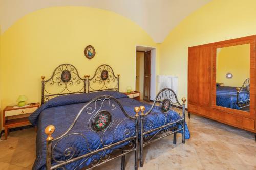 a bedroom with a blue bed and a mirror at Casa vacanze da Medardo in Gagliano Aterno