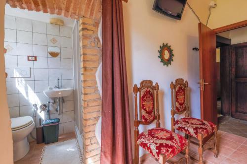 a bathroom with a toilet and two chairs in it at Casa vacanze da Medardo in Gagliano Aterno
