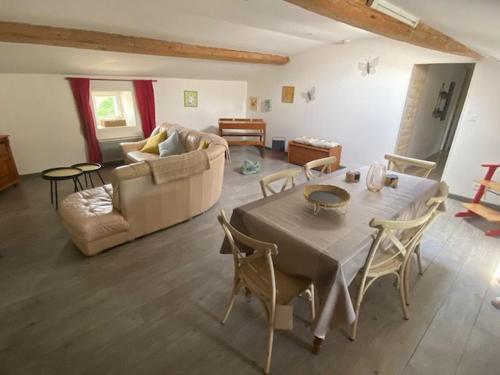 un salon avec une table et un canapé dans l'établissement Gîte familial avec jardin privatif, plancha et jeux, proche de La Rochelle - FR-1-426-263, à Sainte-Gemme-la-Plaine