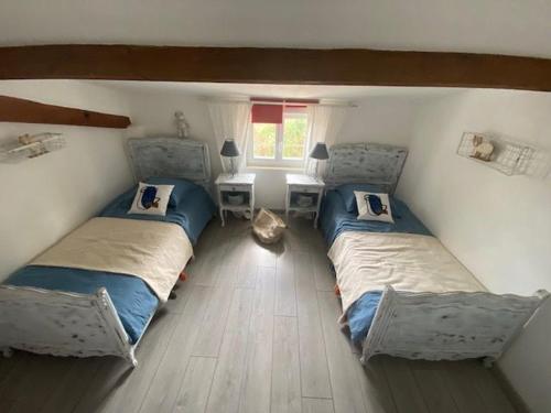- une chambre avec 2 lits et une table avec une fenêtre dans l'établissement Gîte familial avec jardin privatif, plancha et jeux, proche de La Rochelle - FR-1-426-263, à Sainte-Gemme-la-Plaine