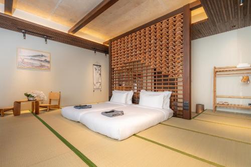 a bedroom with a large white bed and a brick wall at Hoshi Hotel Hatyai in Hat Yai