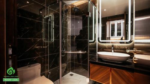 a bathroom with a sink and a shower and a toilet at Thuý Doji Diamond Apartment in Hai Phong