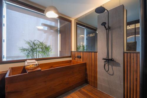 a bathroom with a tub and a large window at Hoshi Hotel Hatyai in Hat Yai