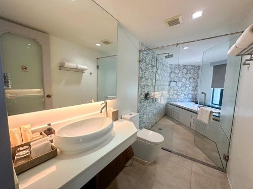a bathroom with a sink and a toilet and a shower at Zenmaya Oceanfront Phuket, Trademark Collection by Wyndham in Patong Beach