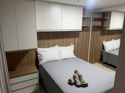 a bedroom with a bed with shoes on it at Apartamento vista privilegiada, DF PLAZA in Brasilia