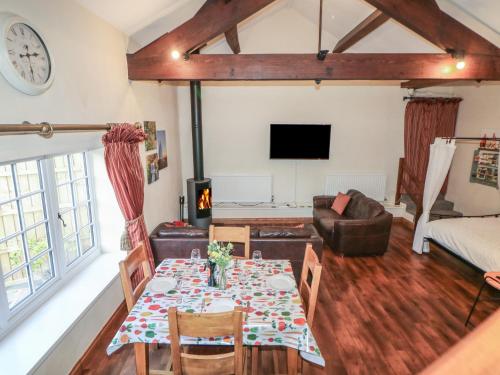 un soggiorno con un tavolo e un divano di Oakenbank Barn a Macclesfield