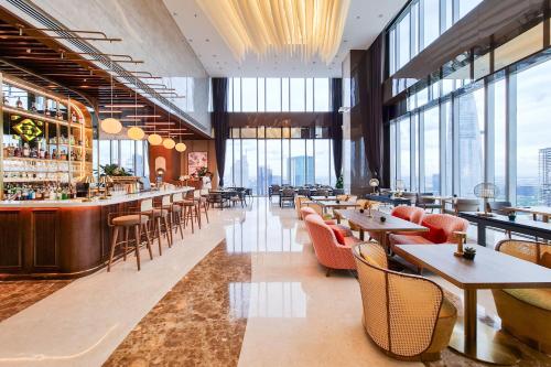 a restaurant with tables and chairs and windows at Sedona Suites Ho Chi Minh City in Ho Chi Minh City