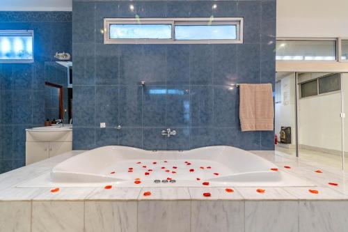 a large bathroom with a tub with red flowers on it at Luxury mansion in Recoleta - Jacuzzi - Sauna - 40 people in Buenos Aires